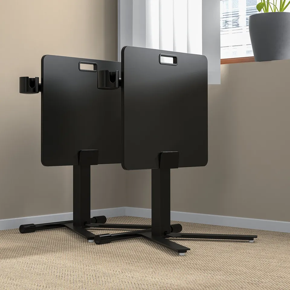 Two height-adjustable laptop tables in office near window, tiltable surfaces, stable stands with castors.