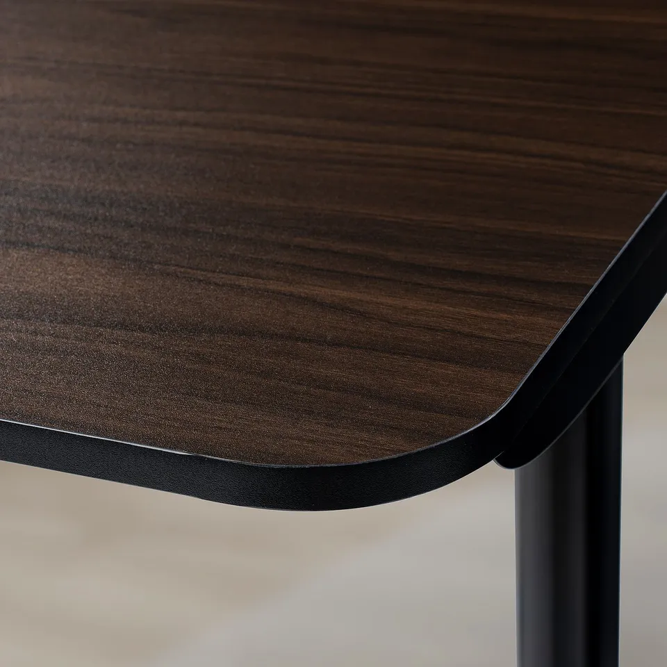 A close-up of a durable, dark wood-finished tabletop with sleek, rounded edges, supported by sturdy black metal legs.