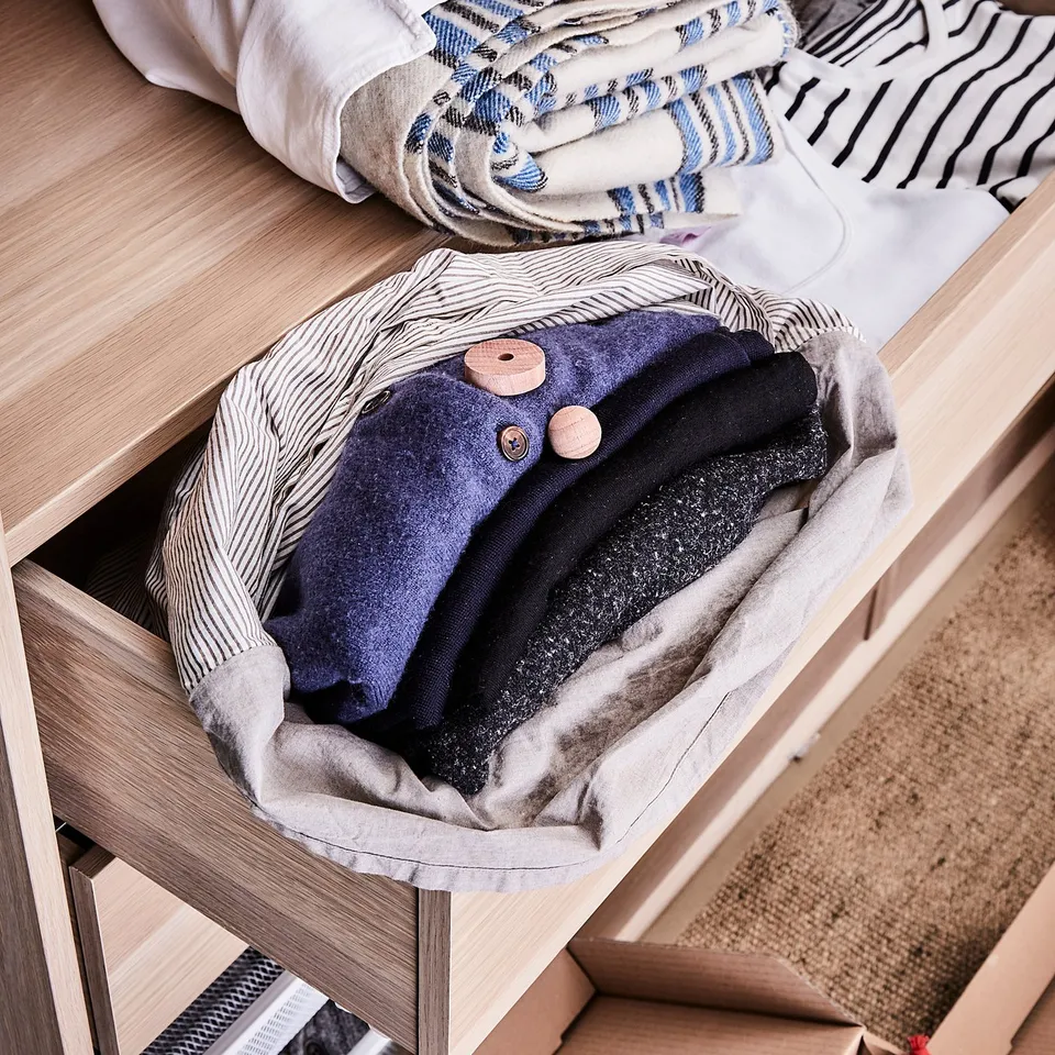 Koterne adjustable shelf with shirts in light blue & navy, organised in grey boxes