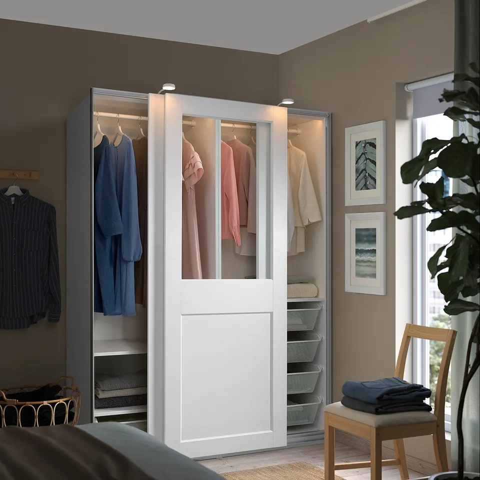 Modern bedroom with PAX wardrobe, glass doors, minimalist decor.