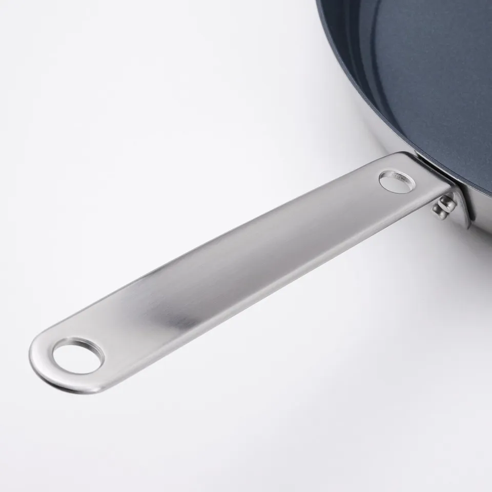 A top-quality stainless steel cookware handle, sleek & polished, securely attached with rivets for durability.