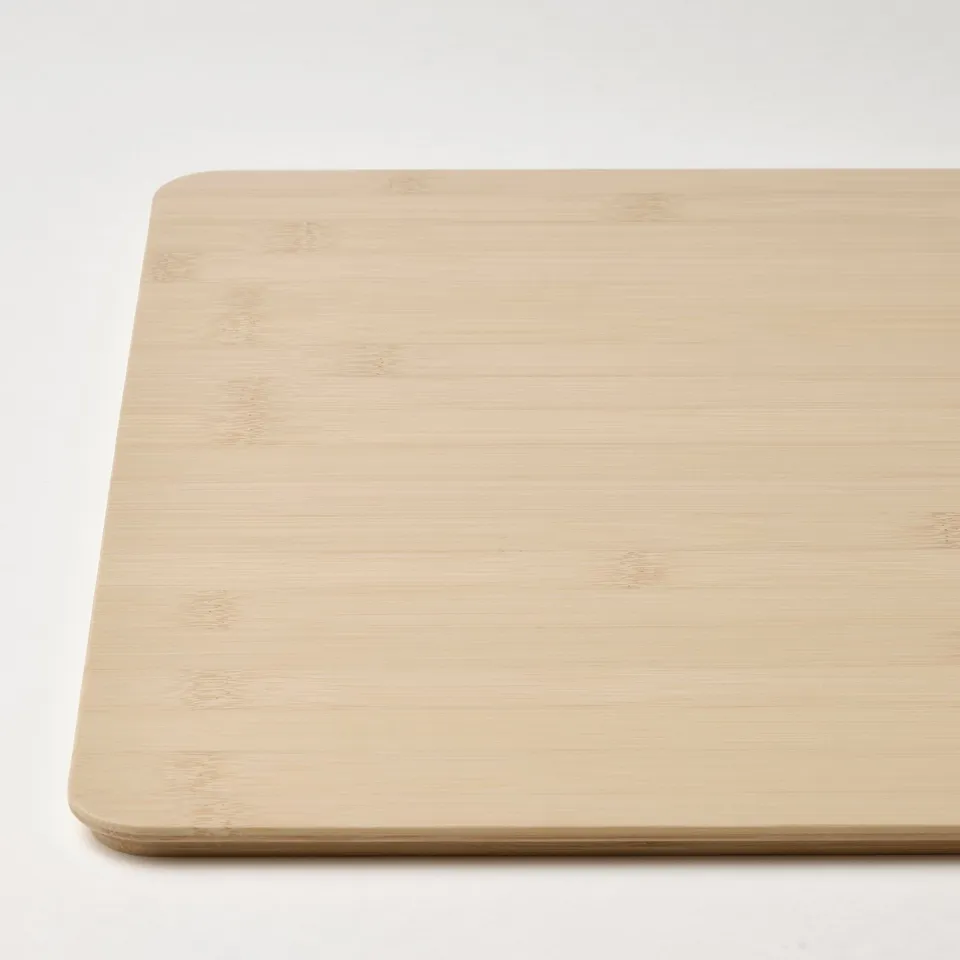 Light wooden cutting board in natural bamboo. Rectangle shape with smooth, rounded edges.