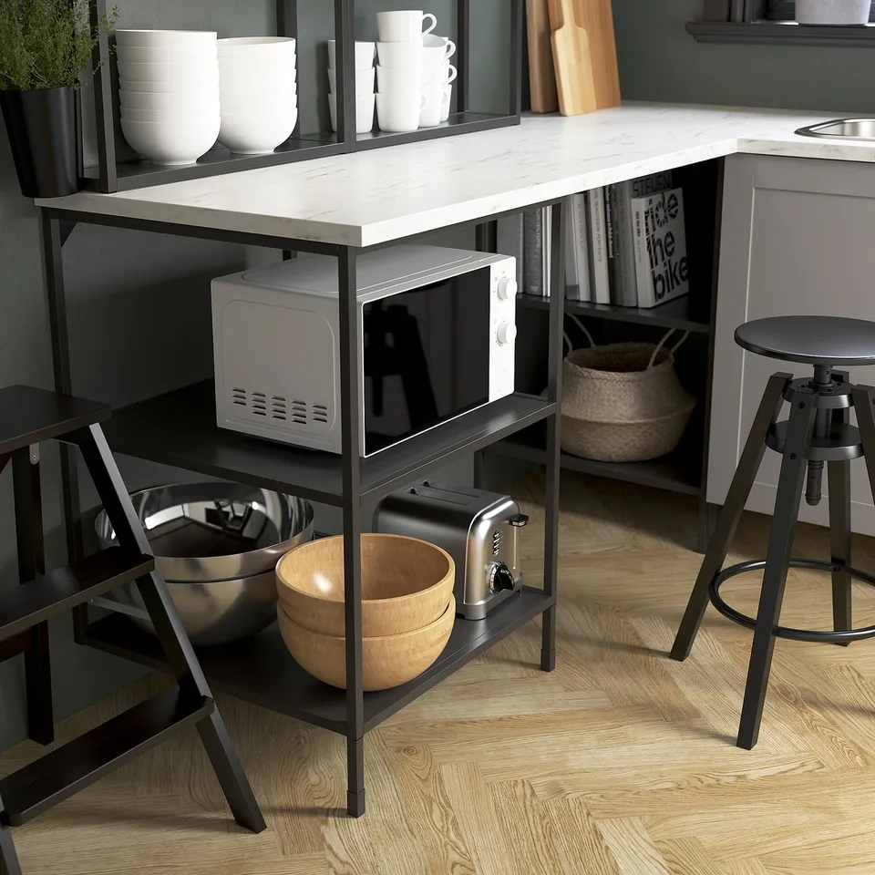 Modern kitchen setup with ENHET open frame displaying a microwave, toaster, and bowls on wooden floors.