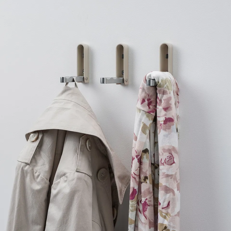 Three hooks hold coat, scarf, and are empty. Or, hooks hold coat, scarf, one empty.