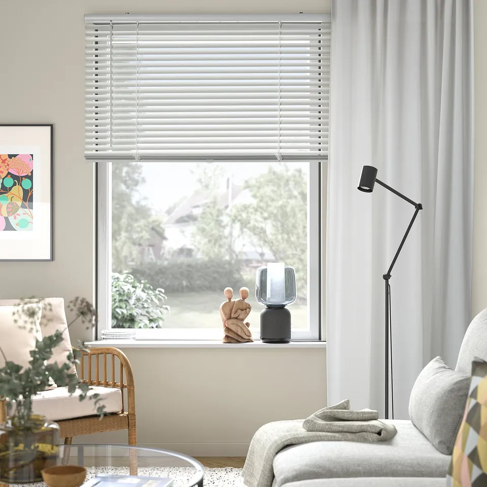 Modern living room with VECKLARFLY blinds, lamp, sofa, and painting.