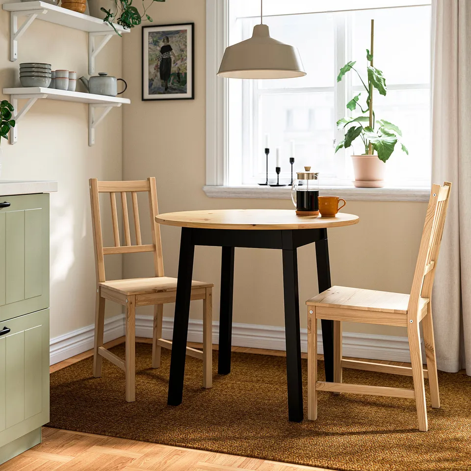 Small kitchen nook with round brown PINNTORP table and light wood chairs, cosy and rustic.