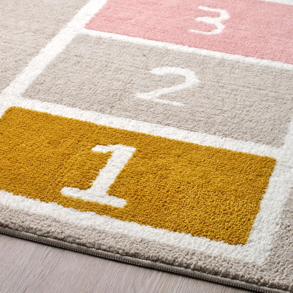 Colourful hopscotch rug with soft, plush texture; yellow, grey, and pink squares, numbered 1-3.