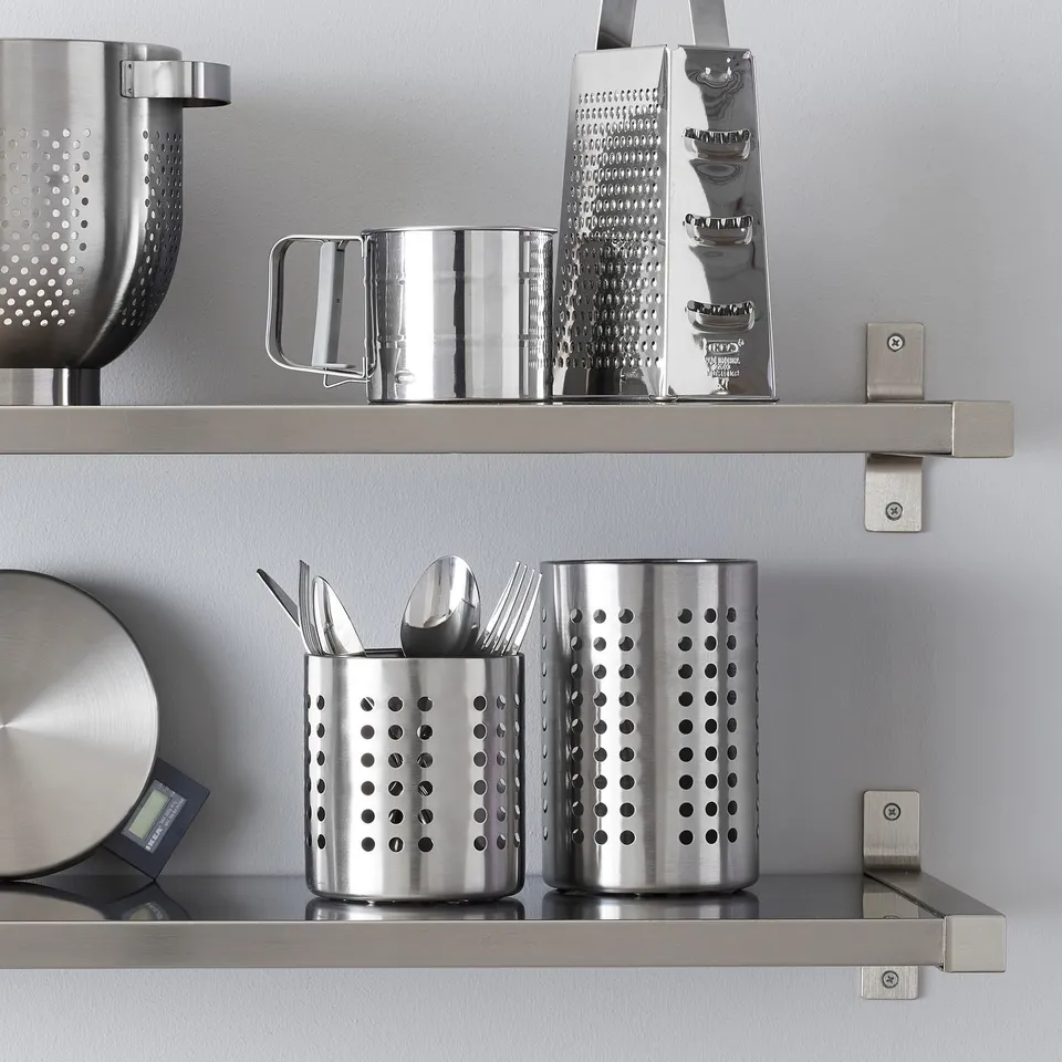 Stainless steel kitchen organiser with cutlery and utensils on shelves.
