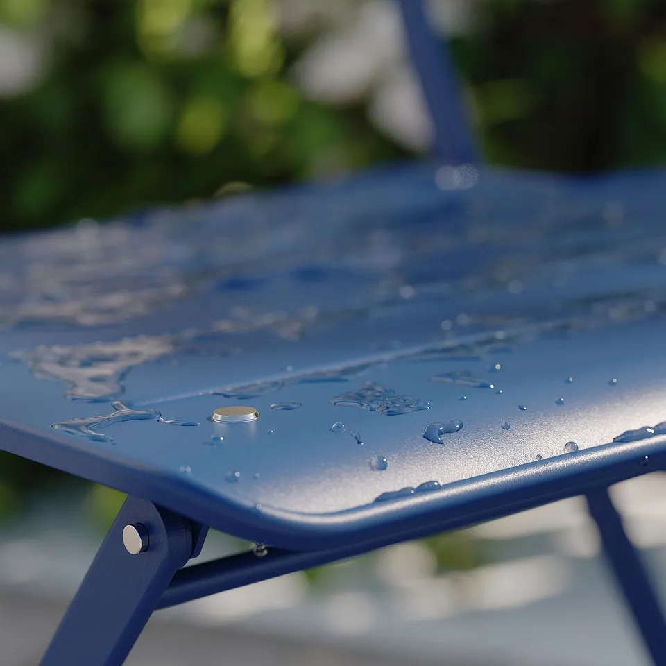 Blue metal outdoor table with water droplets, partially folded, set outdoors.