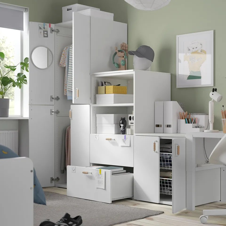 A modern bedroom featuring a white SMÅSTAD wardrobe with open shelves, a hat, and a headphone organiser, ideal for a childs changing style.