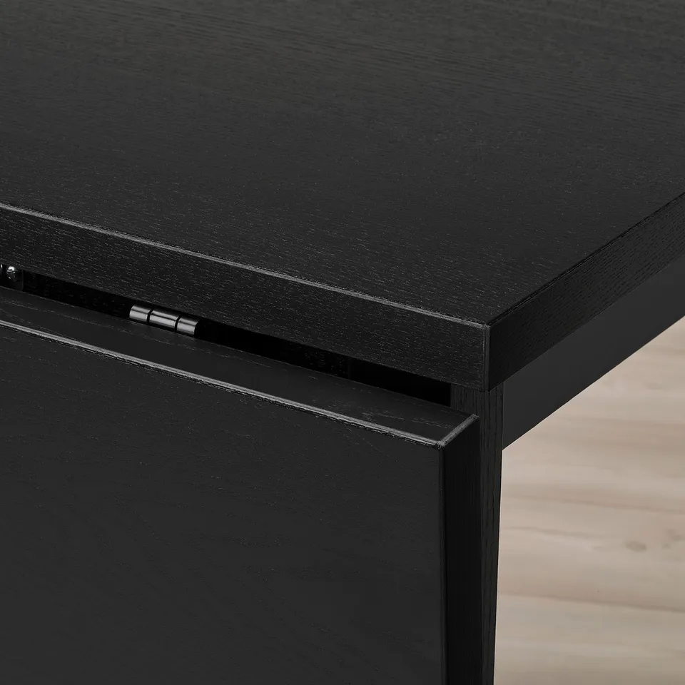 Close-up of sleek black table, smooth finish, sturdy hinge.