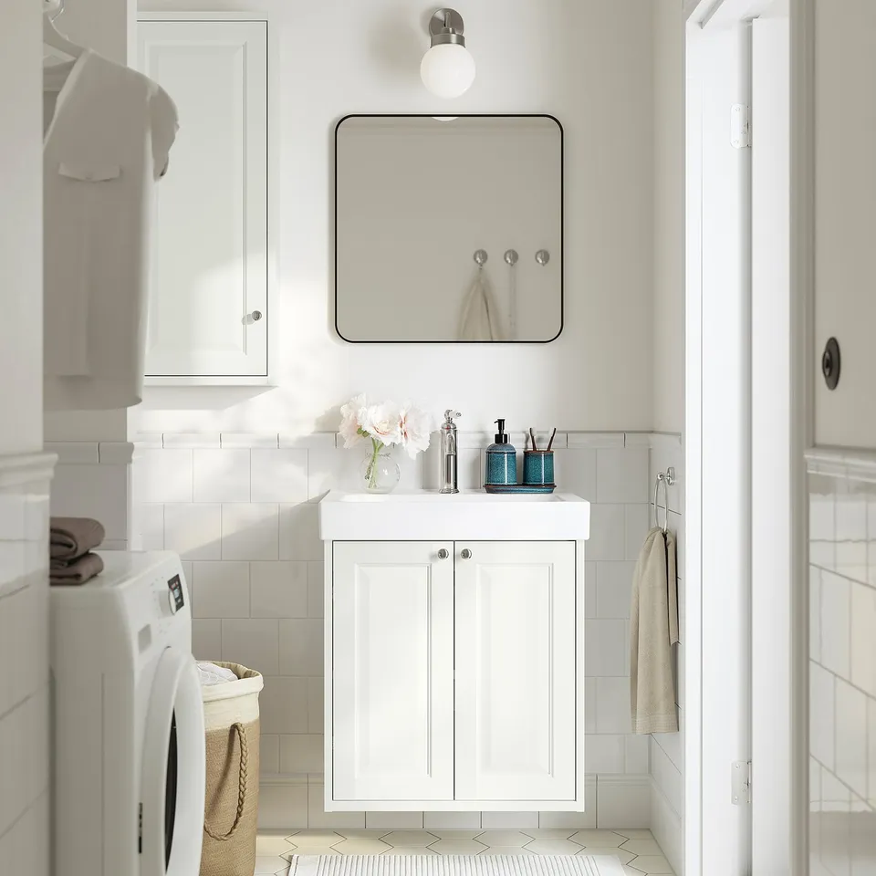 White TÄNNFORSEN vanity, mirror, deep sink, washing machine, storage.