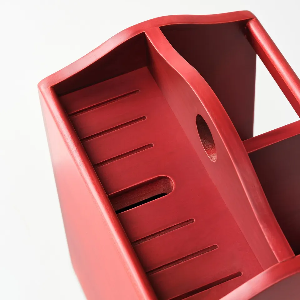 Red wooden knife block, acrylic painted, holds multiple knives and utensils.