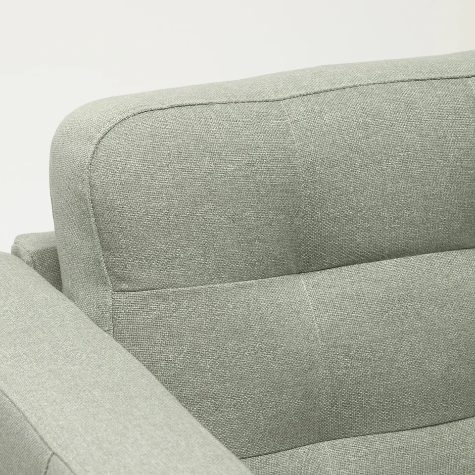 A modern sofa with a light grey fabric cover, showcasing high-quality stitching and plush cushions, providing a sense of comfort and style.
