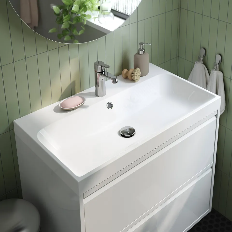 Modern bathroom vanity with sleek white sink, chrome tap, and drawer storage.