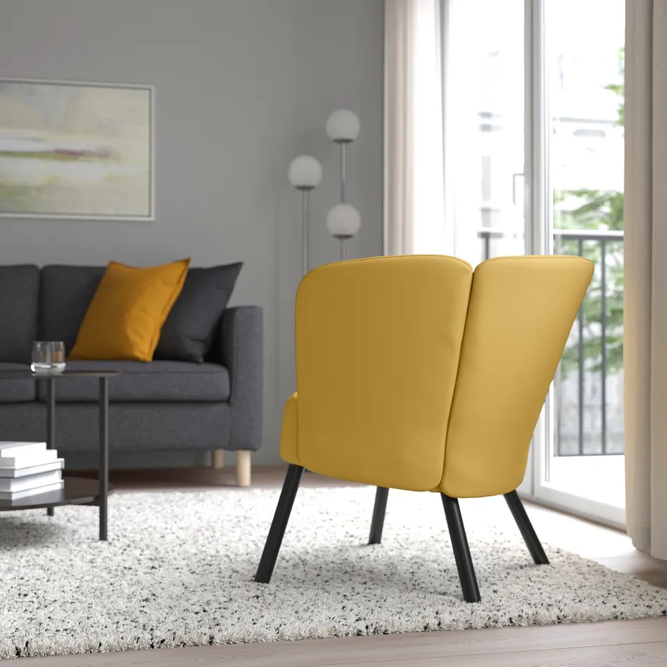 Modern living room with yellow armchair, grey sofa, and coffee table. Bright natural light from window.
