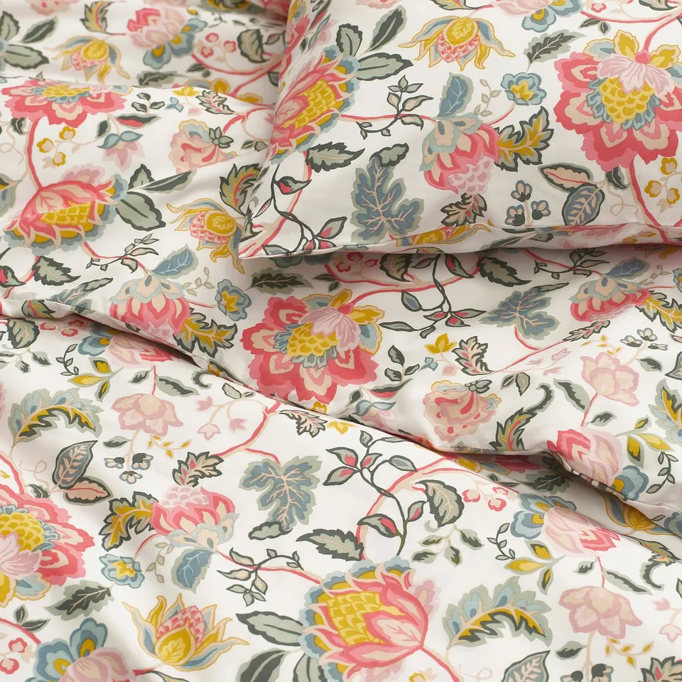 Floral bedding set with vibrant flowers, smooth fabric, creased neatly.