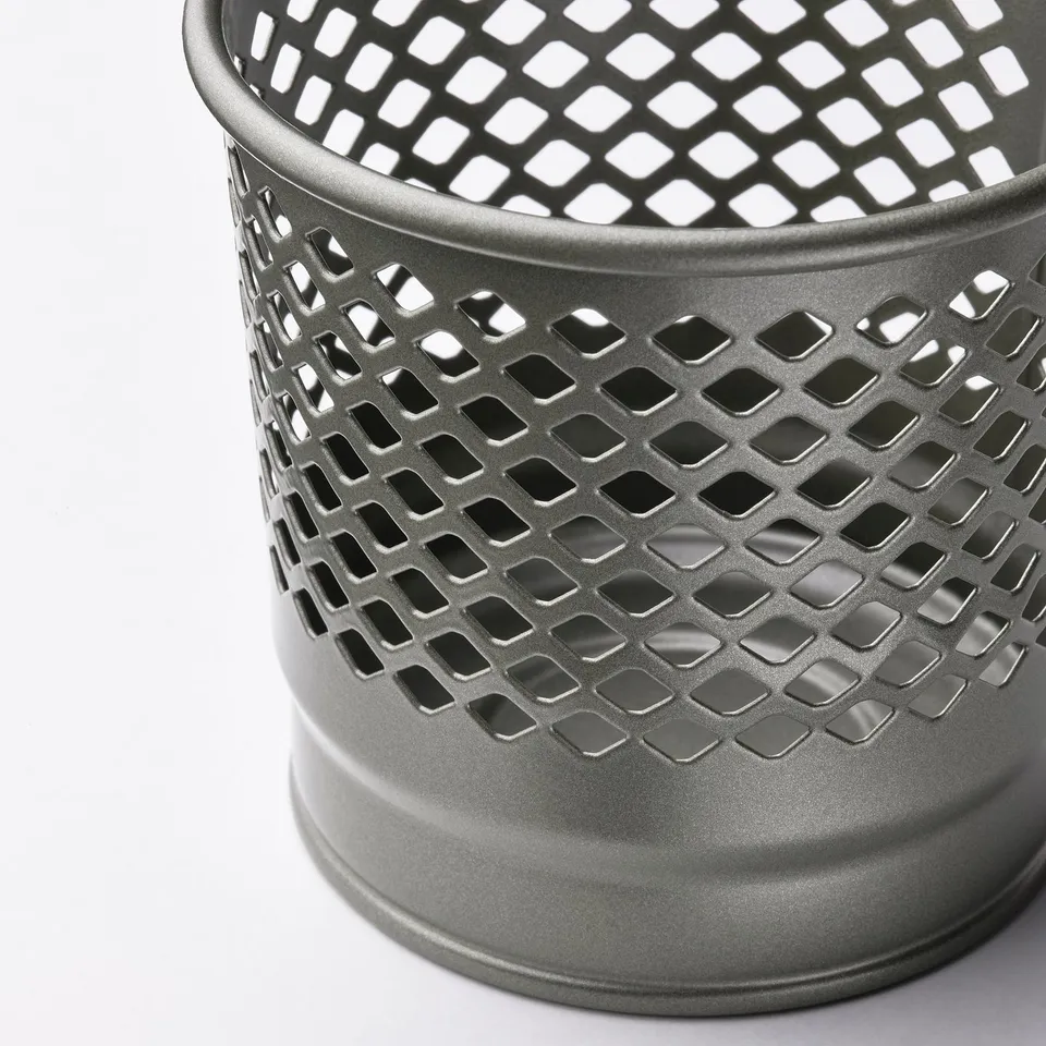 Metal candle holder with intricate cutouts, emits soft glow, sleek and modern.