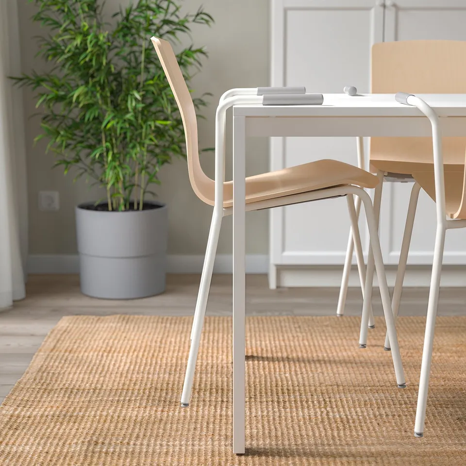 Birch veneer LÄKTARE chairs stacked on rug with plant.
