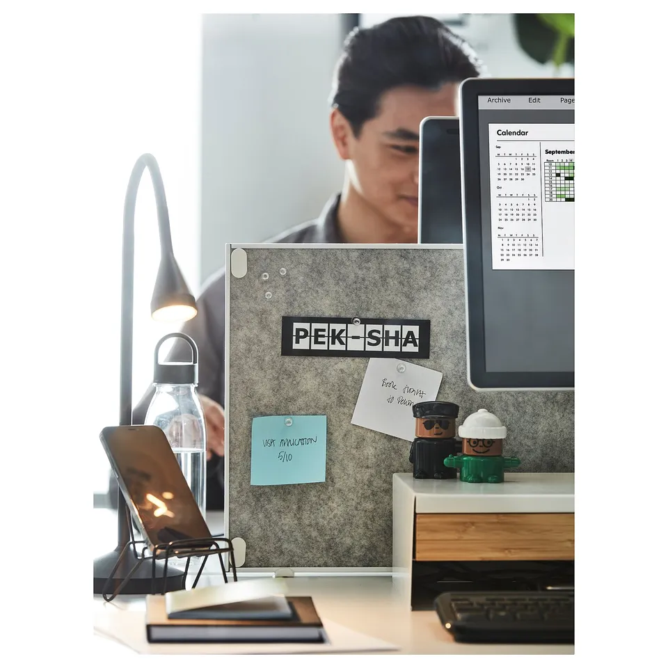 Modern workspace with double-sided desk notice board. Organised with laptop, keyboard, and desk accessories.
