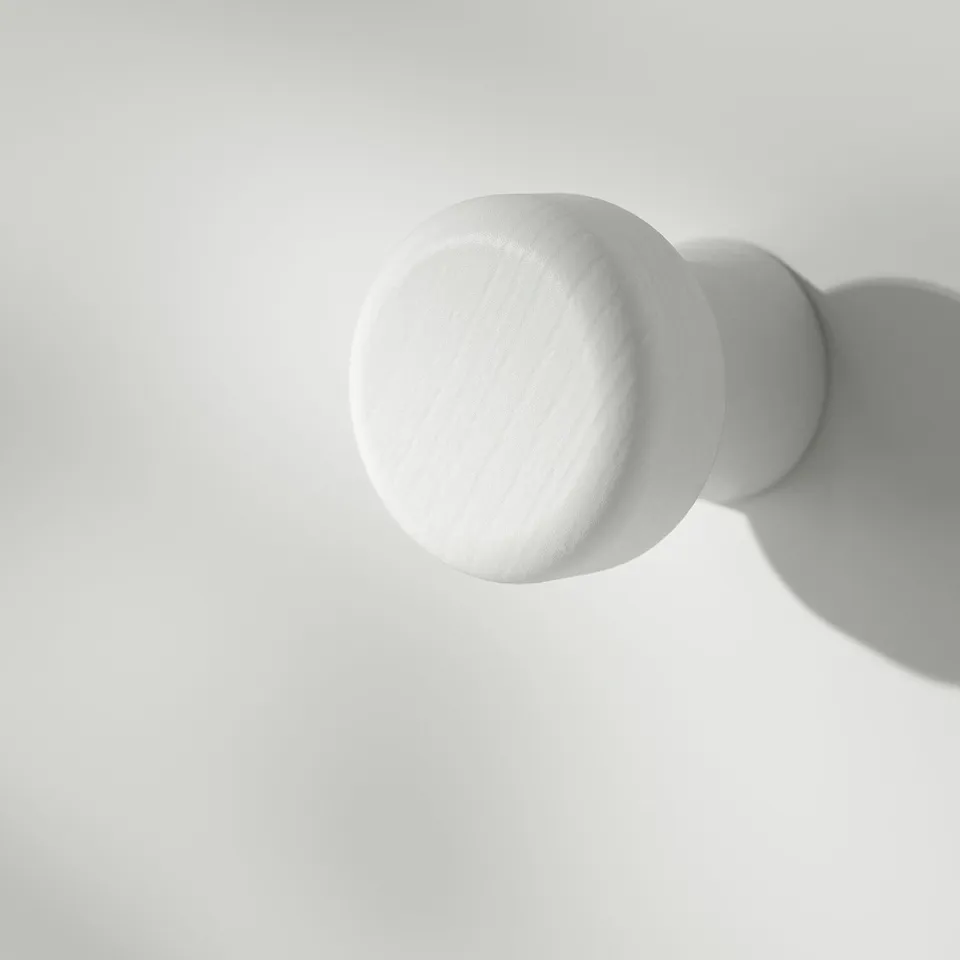 Clean, round knobs on wooden cabinet. Smooth texture, reflective surface. Simple, classic design.