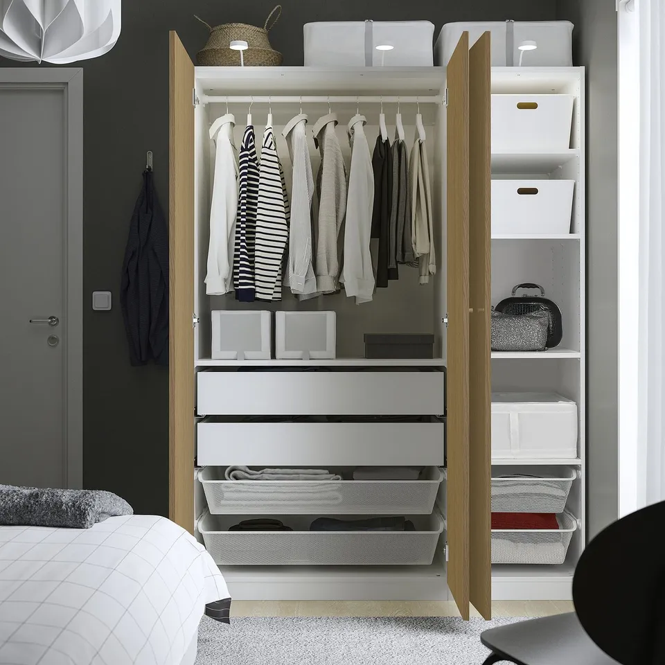 Open wardrobe with clothes, shelves, storage, and mesh baskets.