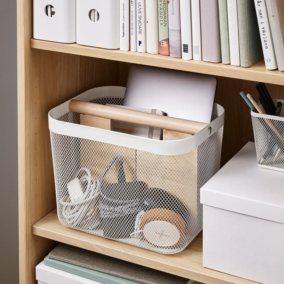 Mesh storage basket on shelf, holding laptop and wooden items, organised with divider, ideal for work or home.