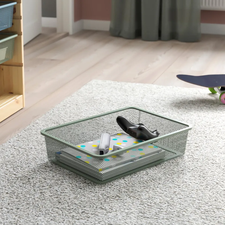Mesh storage basket with video game controllers inside, part of TROFAST series for organising items.