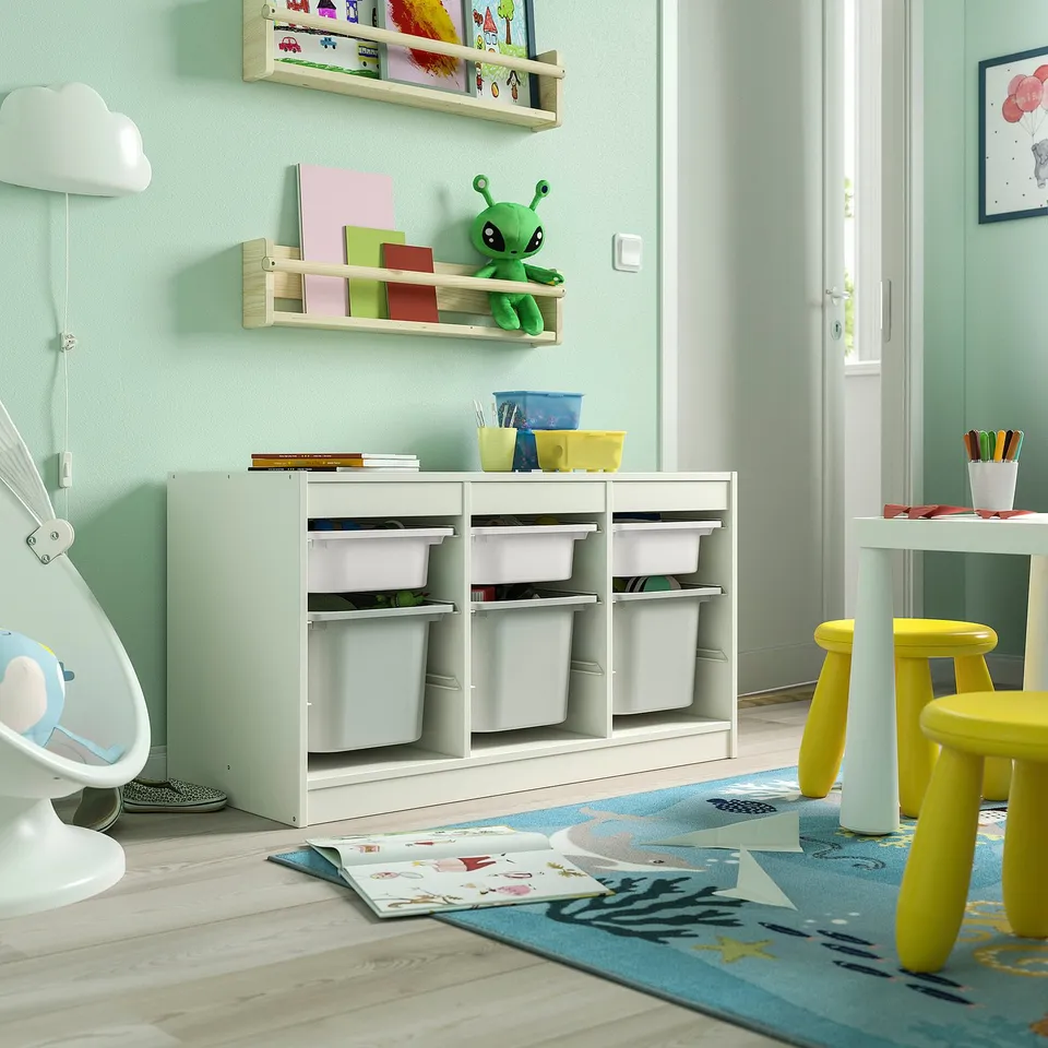 Playroom with TROFAST storage unit, light green, wooden, low, cubes for storage, near yellow chairs and open door.
