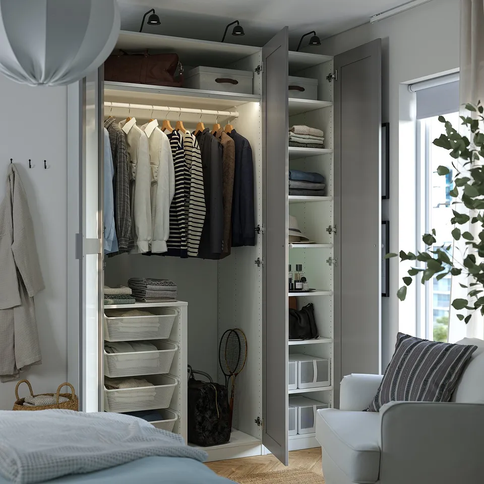 Organised wardrobe with hanging shirts, folded clothes, and accessories. Includes shelves, drawers, and a storage bin.