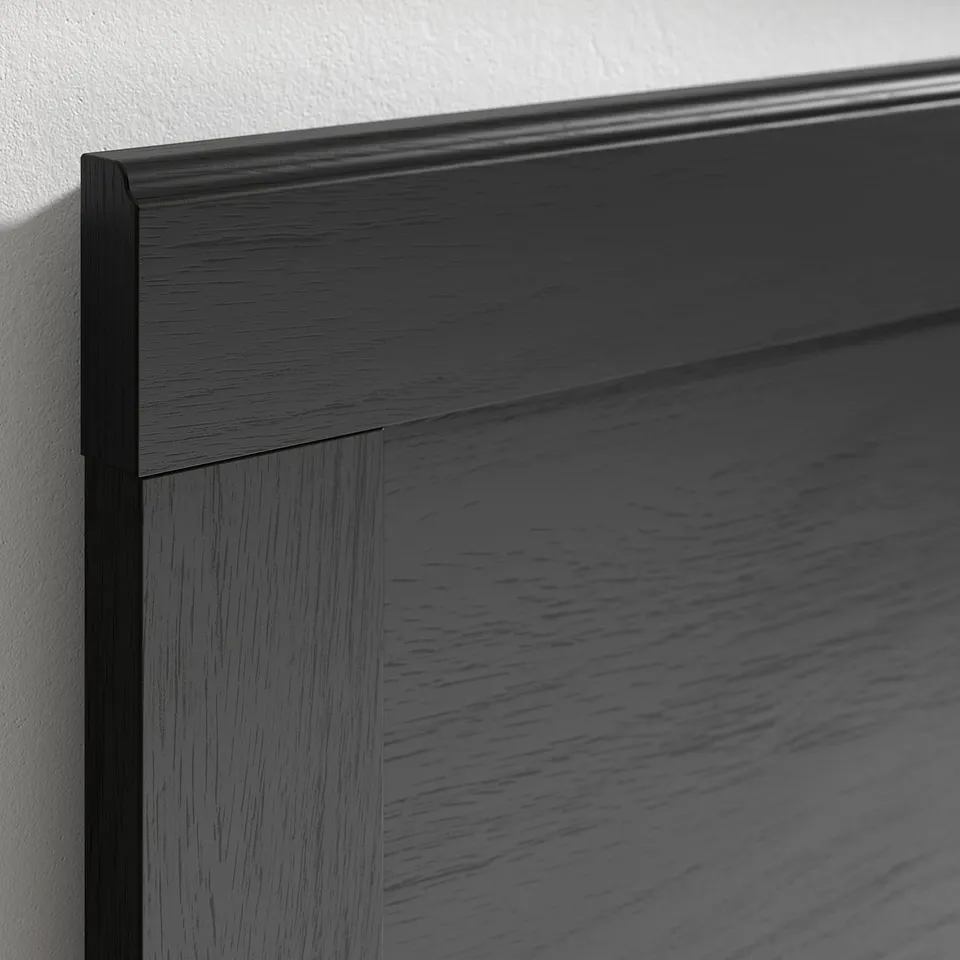 Dark wooden bed frame close-up, showcasing sleek, smooth finish and sturdy construction.