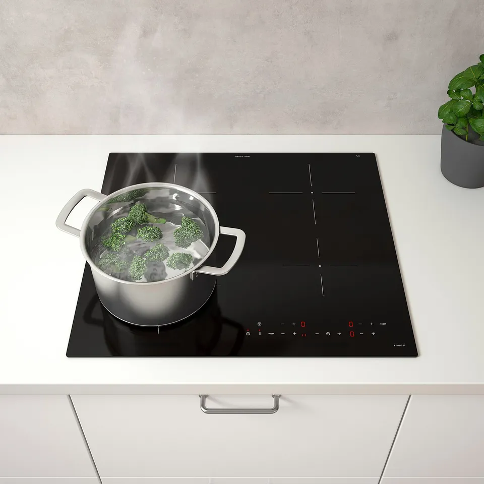 Modern kitchen with MATMÄSSIG induction cooktop, boiling broccoli on front left, efficient digital controls.