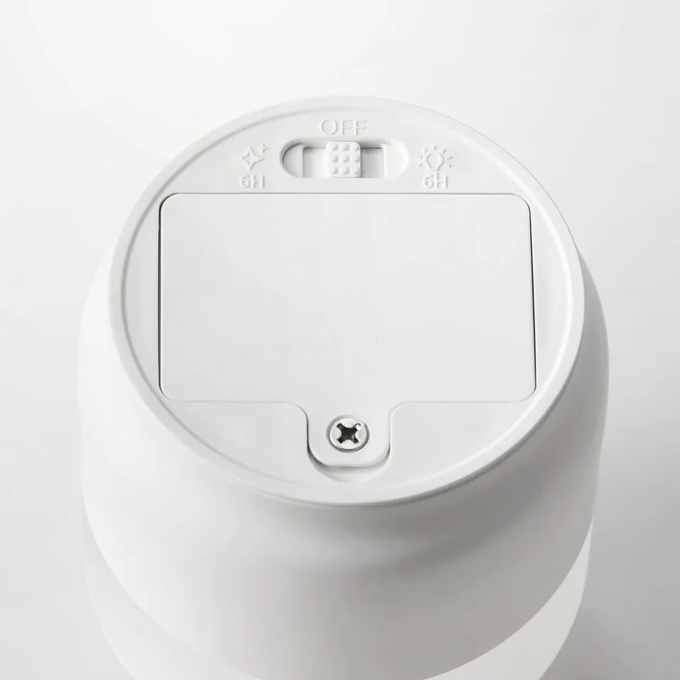 Top view of a sleek, white, cylindrical led candle with timer control buttons and frosted glass surface.