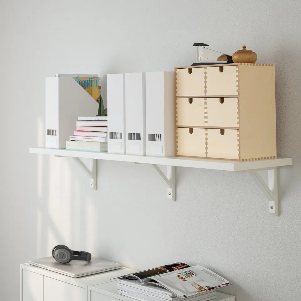 Modern wall shelf with books, box, drawers, radio, cabinet, headphones, magazine.