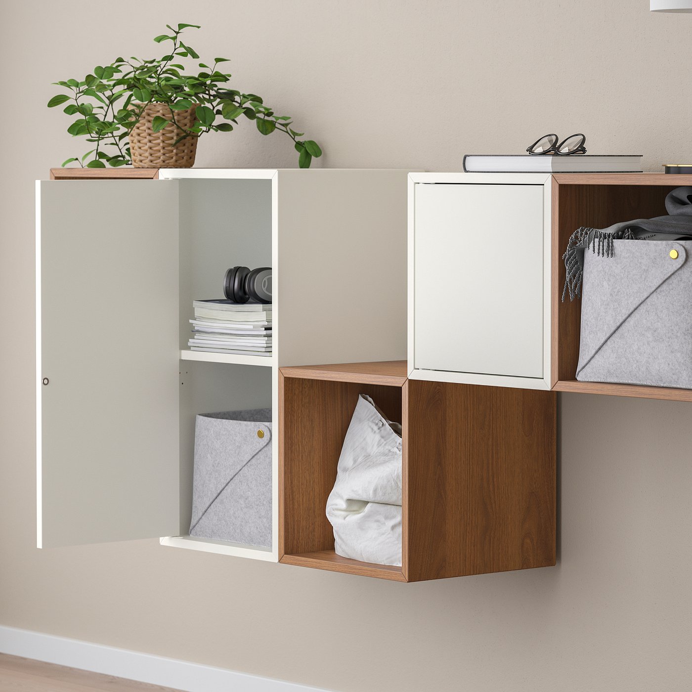 Wall storage with open/closed compartments. Holds cloth, books, headphones, plant. Doors have integrated openers.