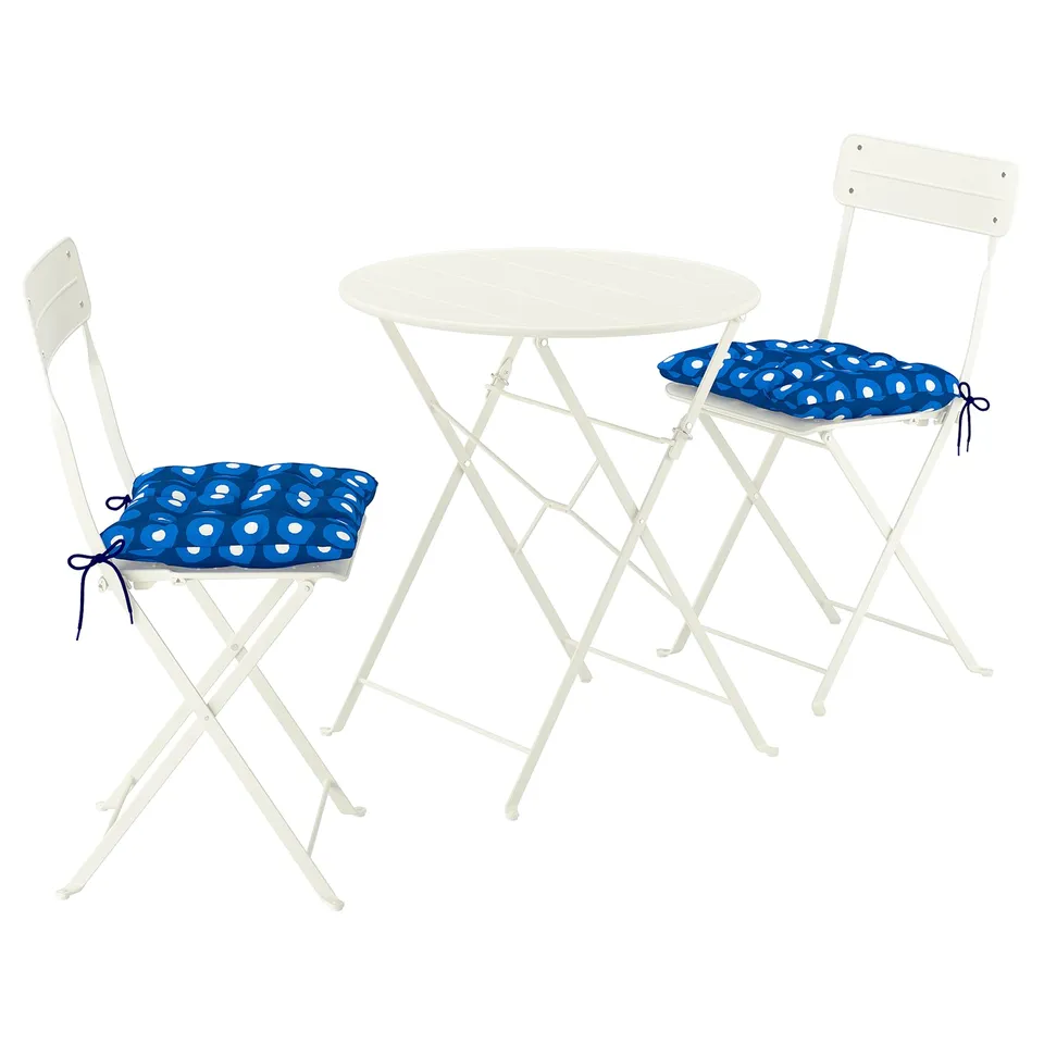 A sundso white metal outdoor set with a round table and two chairs, each with a blue polka-dot cushions.