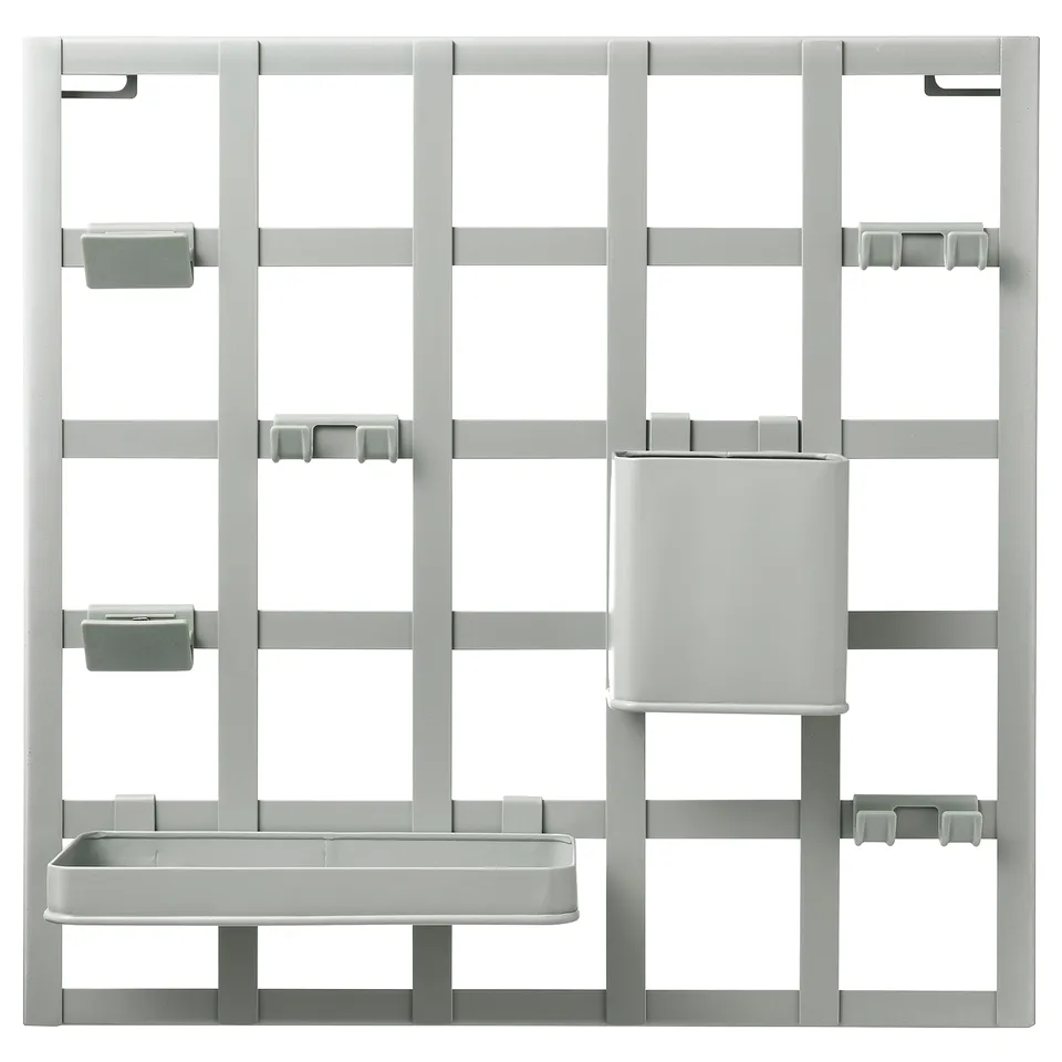 A grey SNICKRA storage board with hooks, clips, a container, and a shelf for organising small items.