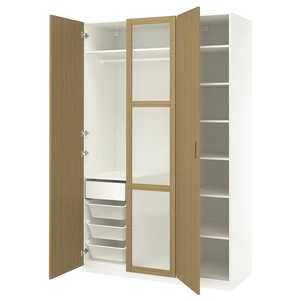 An ikea PAX wardrobe with wooden doors, white interiors, and mesh drawers.