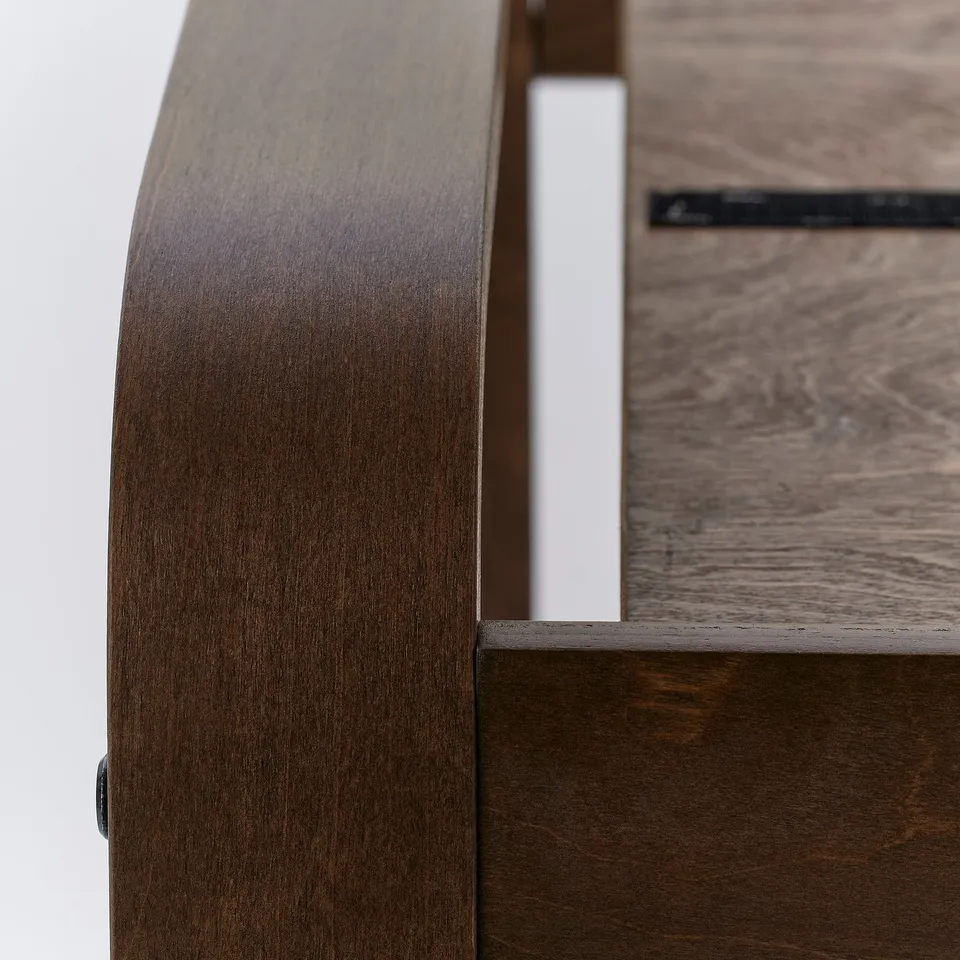 Close-up of POÄNG furniture in dark wood, showcasing smooth, curved bentwood design and high-quality craftsmanship.