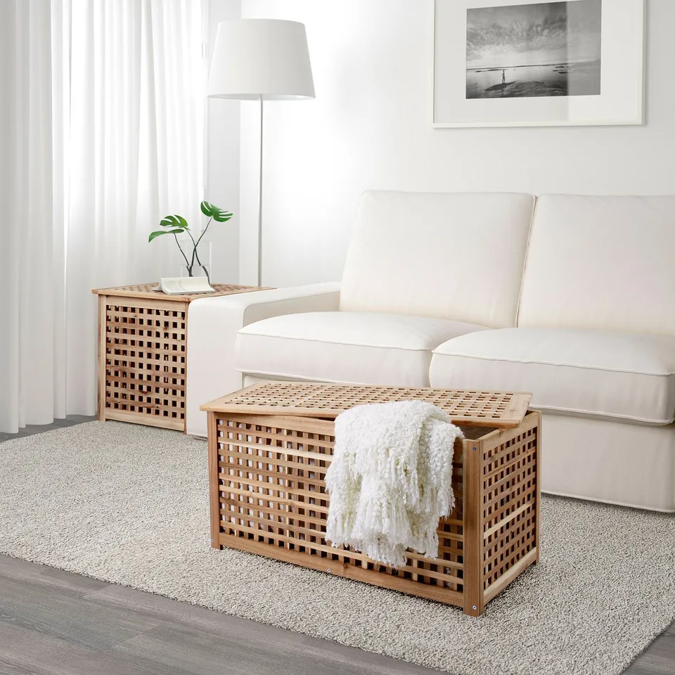 Wooden lattice side table and storage bench with blankets by sofa.