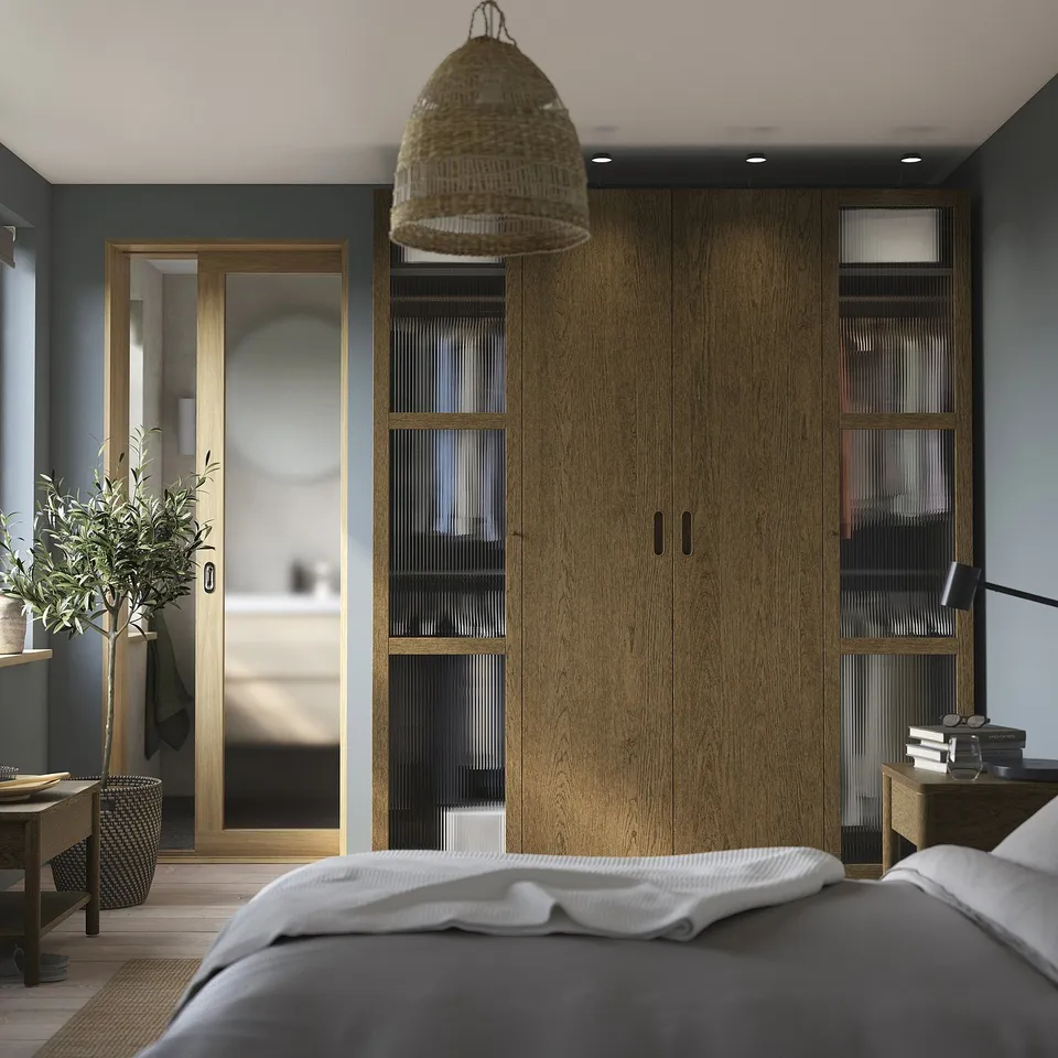Minimalist bedroom with tall PAX wardrobes, hanging light basket, white bedding, and olive tree.