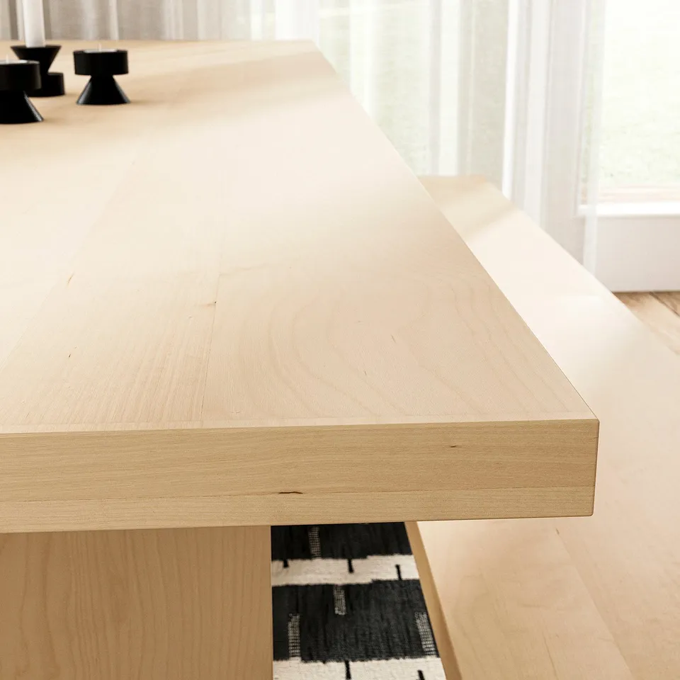 A sleek, light wood dining table with smooth, even grain, showcasing high-quality craftsmanship.