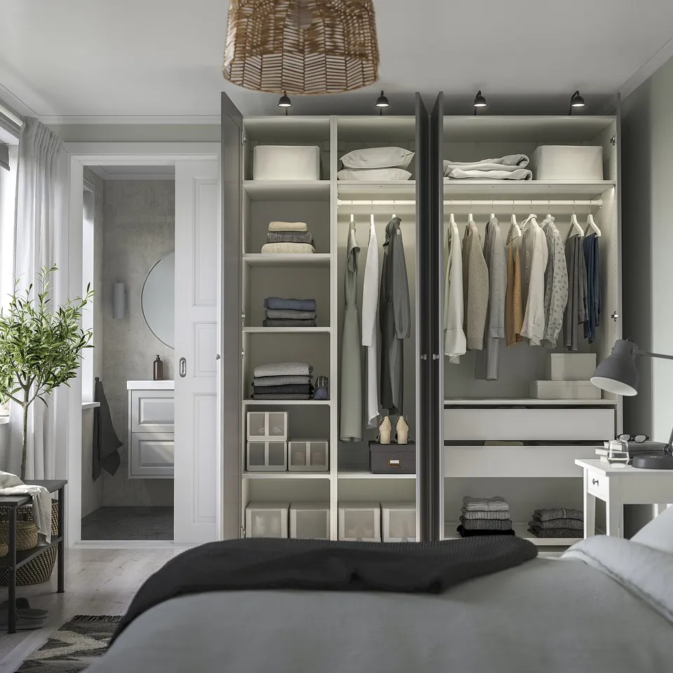 A modern bedroom with a built-in wardrobe featuring adjustable shelves, hanging space, and integrated lighting.