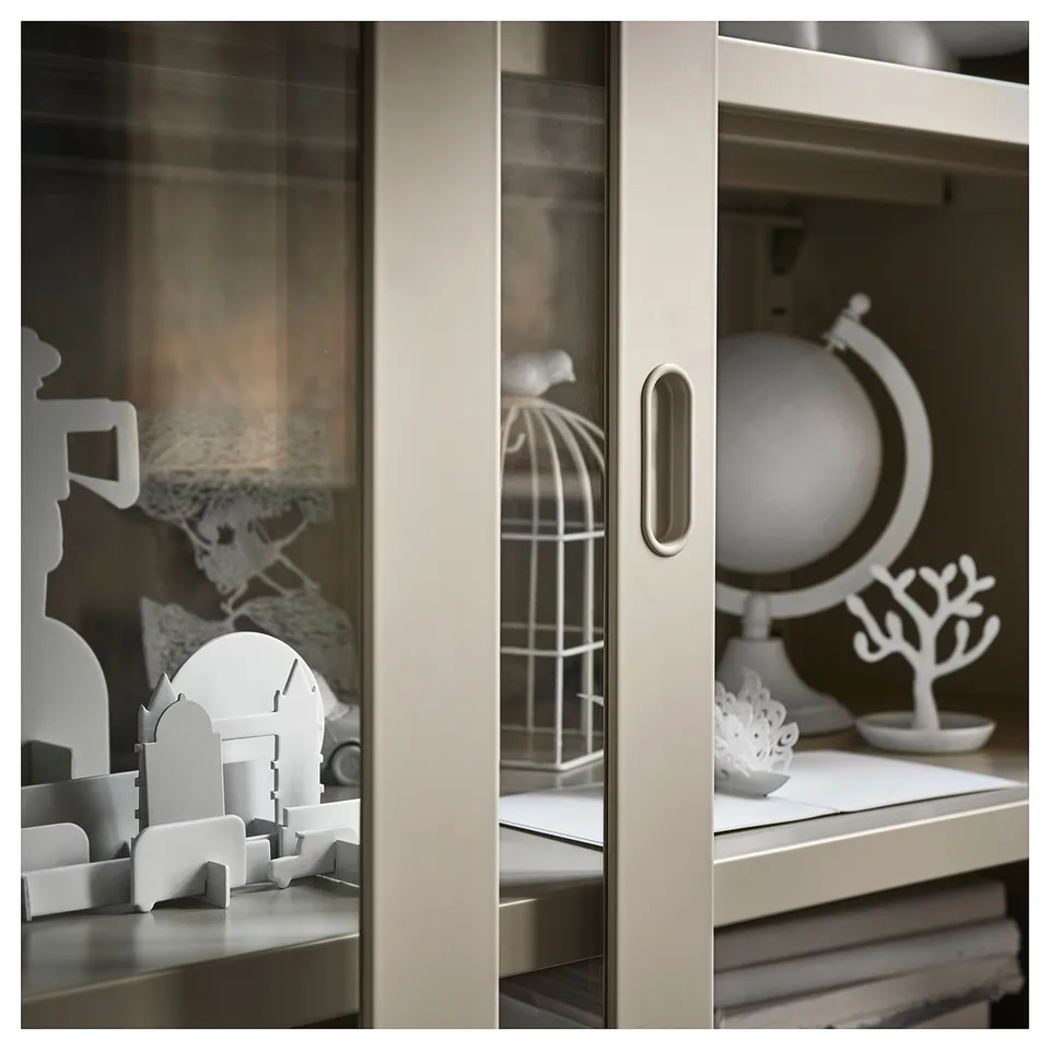Modern IDÅSEN cabinet with sliding doors, white, glass and metal, displaying decorative items.
