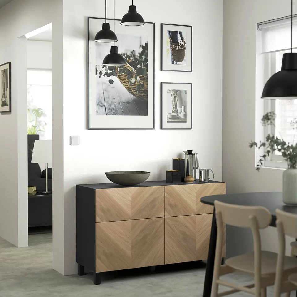Modern room with wooden sideboard, bowl, coffee maker, clothes, photos, lamps, chairs, and curtained window