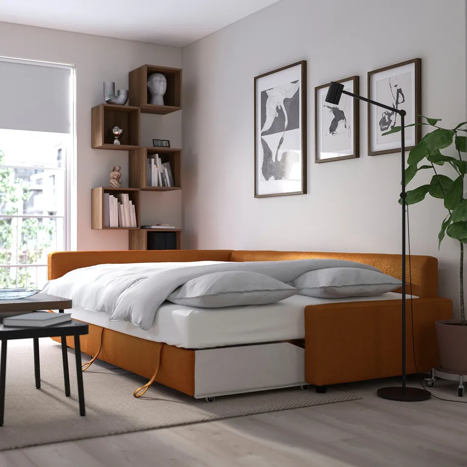 Modern sofa-bed combo with storage, featuring a cosy orange seat, white bedding, and wooden shelves.