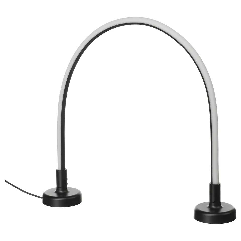 A sleek, curved led lamp named SMÅSNÖRE, available in black and silver. Its modern design a flexible neck and a weighted base.