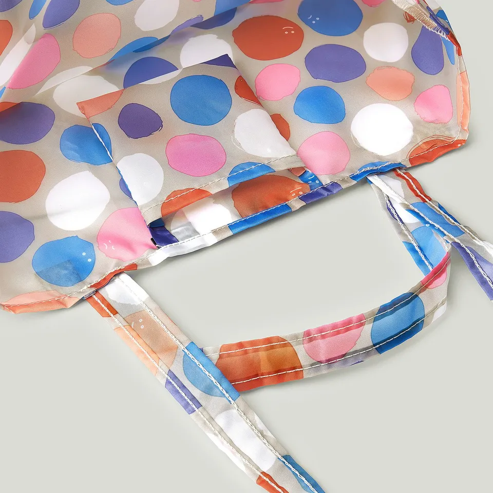 Foldable, colourful bag with polka dot pattern, durable straps and seams, made from recycled polyester.