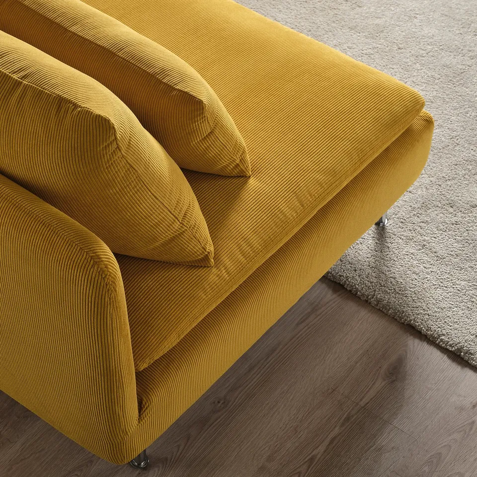 Bright yellow modern sofa with plush cushions, positioned on a hardwood floor next to a soft rug.