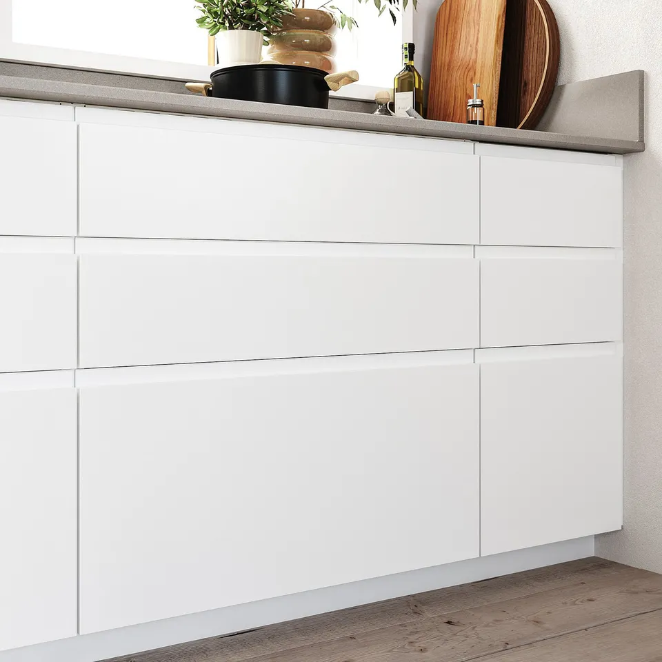 Modern white kitchen cabinets with minimalist design, smooth surfaces, and integrated handles; wooden floor.
